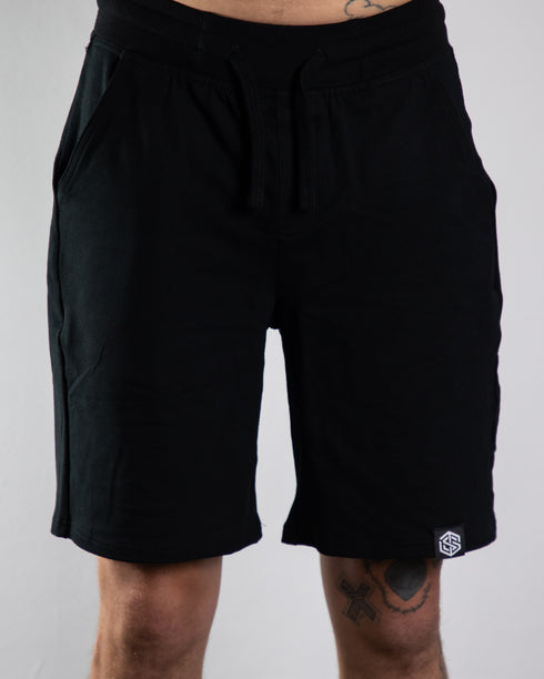 Kurze Raver Hose in schwarz mit Technostoff Weblabel am Hosenbein, von vorne fotografiert
